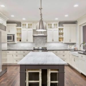 A kitchen with white cabinets and a center island.